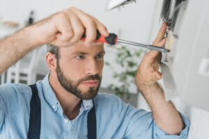 repairman-fixing-air-conditioner-with-screwdriver-at-home.jpg